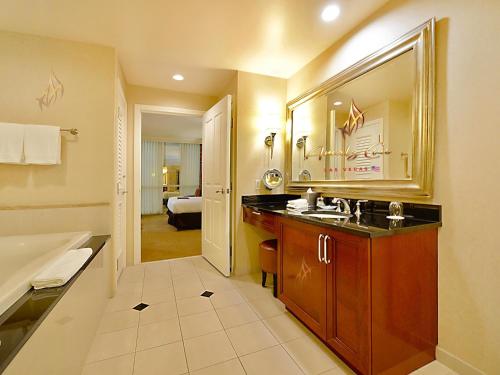 a bathroom with a sink and a tub and a mirror at Amalz Suites Collection at MGM Signature ! in Las Vegas