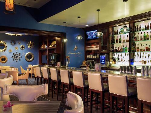 a restaurant with a bar with white chairs at Amalz Suites Collection at MGM Signature ! in Las Vegas