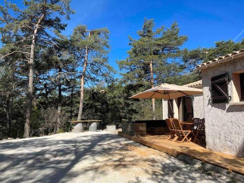 a house with a patio with an umbrella at Les rocailles in Valderoure