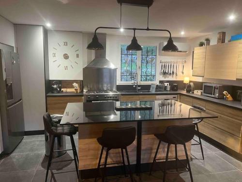 a kitchen with a large island with bar stools at Les rocailles in Valderoure