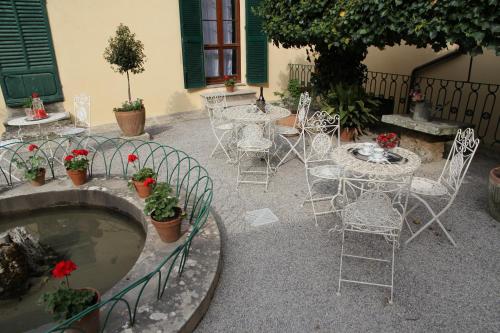 un patio con mesas y sillas y una bañera de hidromasaje. en Residenza Dei Ricci, en Chiusi