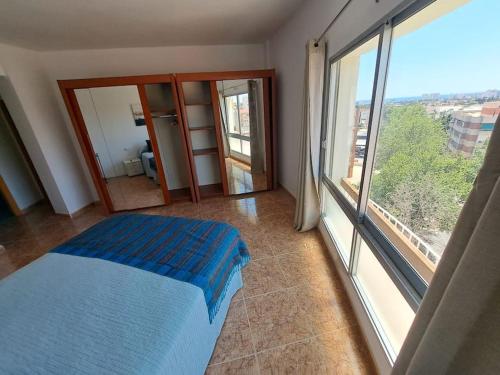 1 dormitorio con cama y ventana grande en Gran Balcón, en San Juan de Alicante