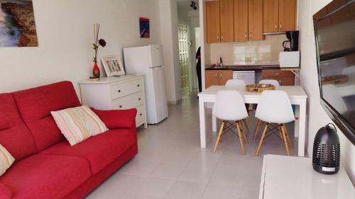 sala de estar con sofá rojo y cocina en Port de la Selva apartament en Port de la Selva