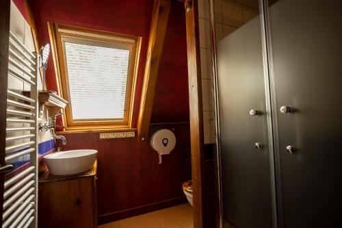 a bathroom with a sink and a toilet and a window at Paradise Cottage - Chalupa v Ráji in Čtveřín