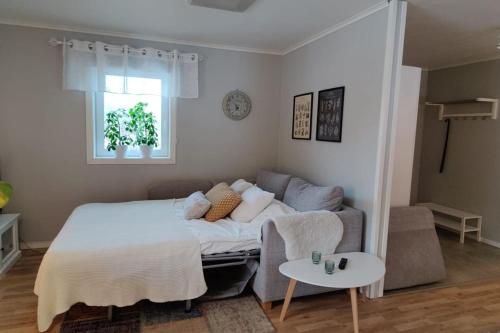 ein Schlafzimmer mit einem Bett, einem Sofa und einem Tisch in der Unterkunft Gästhus nära naturen in Holmsund