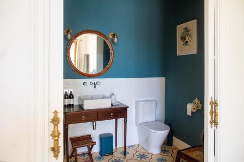 a bathroom with a toilet and a sink and a mirror at Bell Plançó B&B in Moià