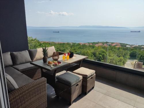 a balcony with a couch and a table with a view at Lunisa VS1 Apartment in Kostrena