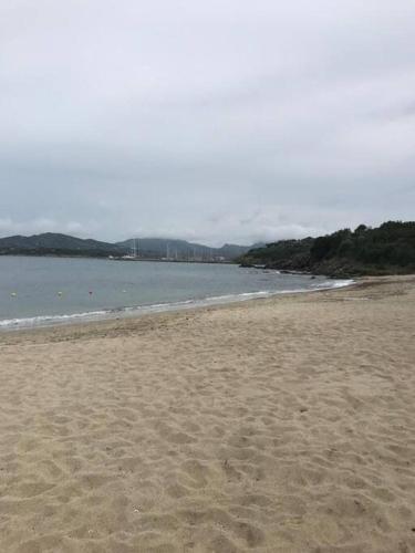 a sandy beach with the ocean in the background at Monolocale a due minuti dal mare IUN R4225 in Marina di Portisco