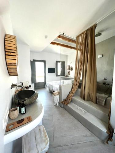 a bathroom with a sink and a tub and a bed at Bohemian Luxury Boutique Hotel, Adults Only in Naousa