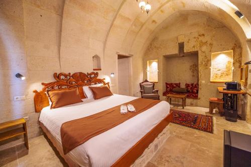 a bedroom with a large bed in a stone room at Canyon Cave Hotel in Urgup