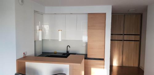 a kitchen with white cabinets and a counter top at Apartament Golden Flight in Warsaw
