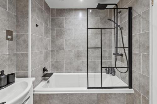 a bathroom with a shower and a bath tub at Riverside Rest 1 - 2 Bedroom Apartment & Free Parking Onsite in Stirling