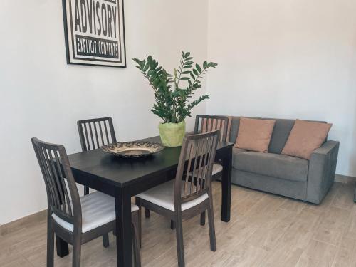 - une table à manger avec des chaises et un canapé dans l'établissement Casa Mirella, à Sanremo