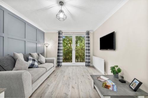 a living room with a couch and a tv at Riverside Rest 1 - 2 Bedroom Apartment & Free Parking Onsite in Stirling