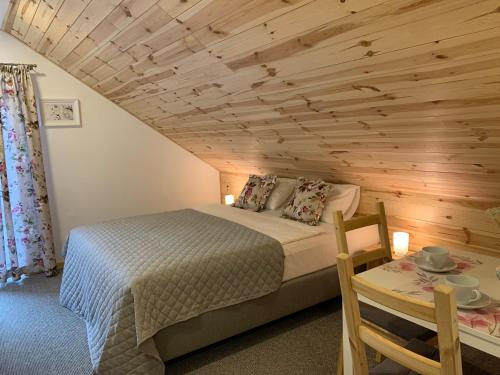a bedroom with a bed and a wooden ceiling at Modrzewiowe Zacisze in Chocieszow