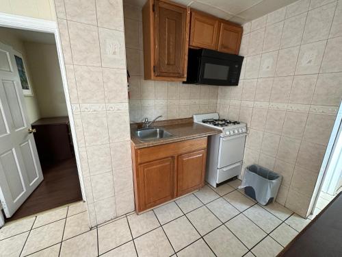 uma pequena cozinha com um lavatório e um fogão em Shore Beach Houses - 43A Lincoln Ave em Seaside Heights