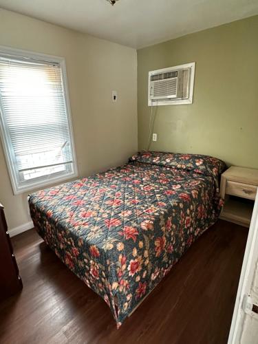a bedroom with a bed with a floral bedspread at Shore Beach Houses - 43A Lincoln Ave in Seaside Heights