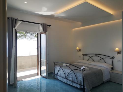 a bedroom with a bed and a sliding glass door at Villa Furoris Apartment in Furore