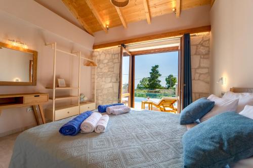 a bedroom with a large bed with towels on it at Pithari Stone Villa in Khalikerí