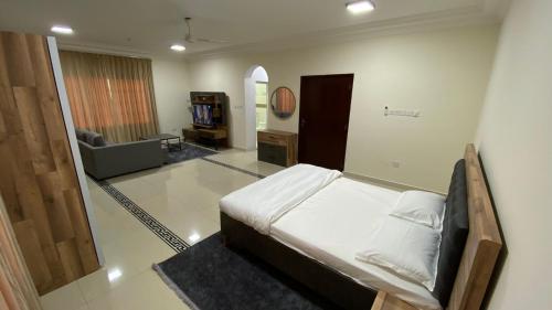 a bedroom with a bed and a living room at AL KALDi in Salalah
