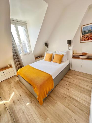 - une chambre avec un grand lit blanc et des draps orange dans l'établissement 5 Stars 2-BR in Center , Air Conditioner , Elevator, à Paris