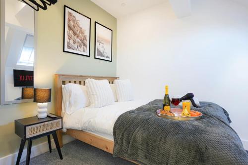 a bedroom with a bed with a tray with wine bottles on it at Central Buckingham Apartment #5 with Free Parking, Pool Table, Fast Wifi and Smart TV with Netflix by Yoko Property in Buckingham
