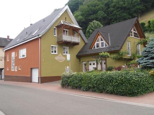 a yellow and orange house on the side of a street at Ferienwohnung yuan in Bruchweiler-Bärenbach