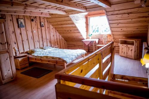 a room with a bed in a wooden cabin at Gospodarstwo Agroturystyczne Kazimierz Januszewski in Dziemiany