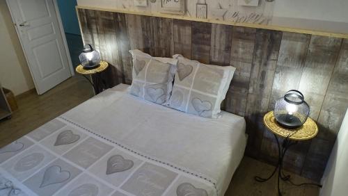 une chambre avec un lit avec des draps blancs et des oreillers dans l'établissement Chambres de Monthéard, à La Bazoge