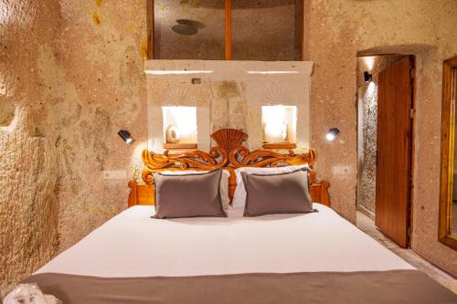 a bedroom with a large bed with white sheets and pillows at Canyon Cave Hotel in Urgup