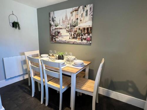 a dining room table with chairs and a painting on the wall at Oak House - 3bed Townhouse with free parking by ShortStays4U in King's Lynn