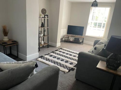 a living room with a couch and a tv at Oak House - 3bed Townhouse with free parking by ShortStays4U in Kings Lynn
