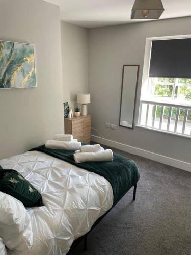 a bedroom with a bed with two pillows on it at Oak House by ShortStays4U A Modern 3Bedroom Townhouse with free parking in town! in King's Lynn