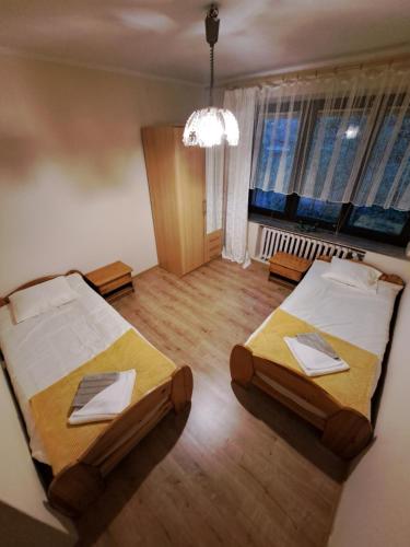 Blisko Krupówek في زاكوباني: غرفة نوم بسريرين وثريا