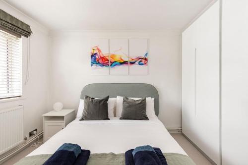 ein weißes Schlafzimmer mit einem großen Bett und einem Fenster in der Unterkunft Spacious light flat in fantastic location! in Eton