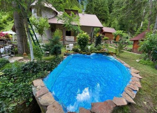 a large blue pool in the yard of a house at Weekend house Grahovača in Rožaje