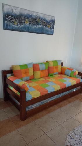 um sofá colorido sentado contra uma parede num quarto em CASA DE CAMPO A TOCA em Guararema