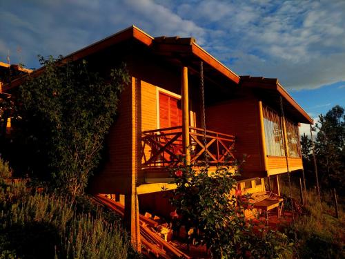 a house with a balcony on the side of it at Chalé Ganesh - O chalé é maravilhoso! in Cunha