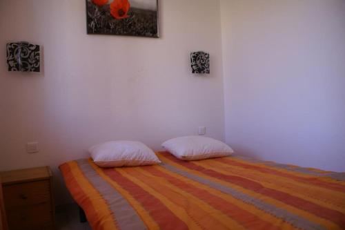 une chambre avec un lit avec deux oreillers dessus dans l'établissement Villa 21, port Venus village au village naturiste, au Cap d'Agde