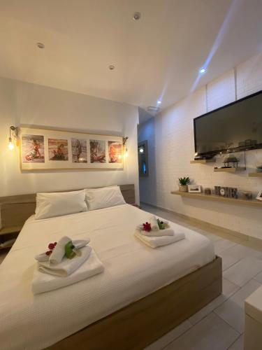 a bedroom with a large white bed with two towels at La casa di mare in Agios Gordios