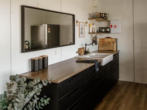 a kitchen with a sink and a mirror at Glenayr Farm in Windeyer