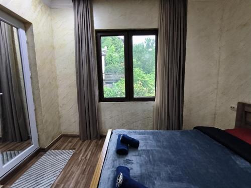 a bedroom with a bed and a large window at Batumi Homestay at Tamar Mephe Avenue in Makhinjauri