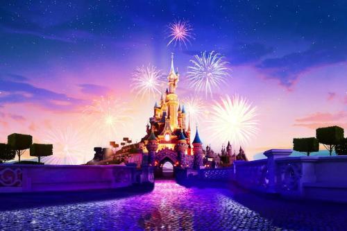 un castillo Disney iluminado con fuegos artificiales por la noche en Société Key-s Meaux/Cerf3/Disney en Meaux