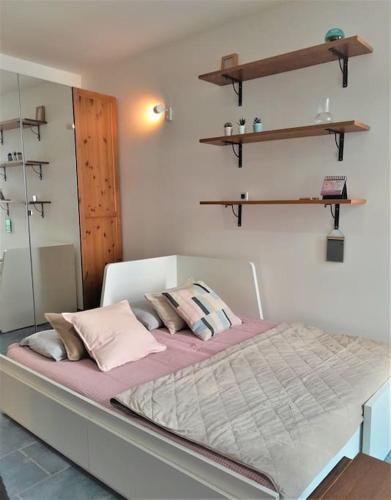 - un lit avec des oreillers roses dans l'établissement Studio Musiciens - CARRE D'OR !, à Nice