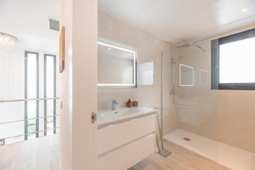 y baño blanco con lavabo y ducha. en Villa Sa Marinada, en Sant Josep de sa Talaia