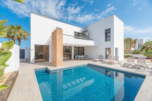 uma villa com uma piscina e uma casa em Villa Sa Marinada | 100m de Mar em San Jose de sa Talaia