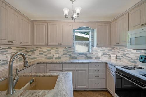a kitchen with white cabinets and a sink at Banyan House Vacation Rentals in Venice