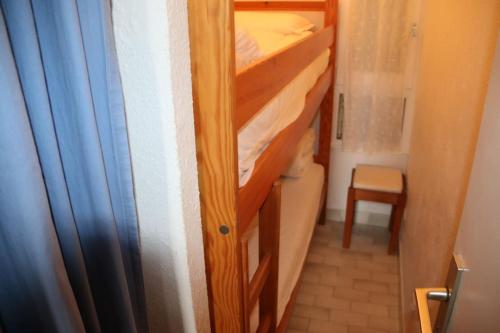 une petite chambre avec un lit superposé dans une chambre avec un placard dans l'établissement Appartement 550, Port Nature 5, village naturiste, au Cap d'Agde