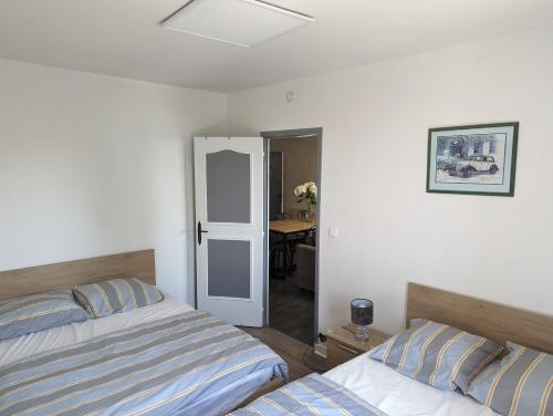 - une chambre avec 2 lits et une table en arrière-plan dans l'établissement Appartement meublé proche du futuroscope, à Poitiers
