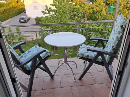 a white table and two chairs on a balcony at Ferienwohnung-Vetter in Bodelshausen